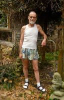 Michael Lowe Wright wearing a tank top and men's skirt with socks and sandals on Wikimedia