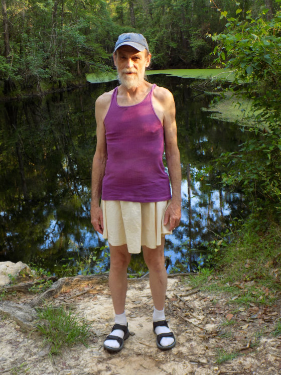 Michael Lowe Wright out hiking in a white skirt, purple tank top, and socks and sandals